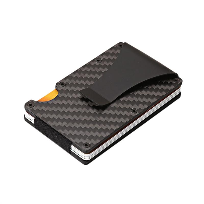 Black carbon-fiber MagShield card holder with a metal clip on a white surface