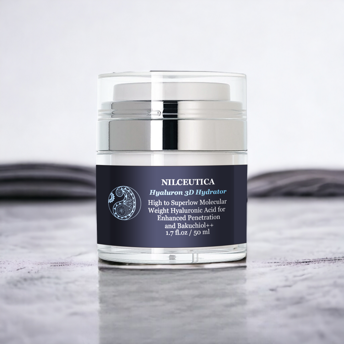 NILCEUTICA moisturizer in a clear and silver airless jar with a dark label, on a gray surface