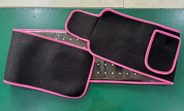 ReviveFlex red light therapy belt in black with pink edging, laid open to show rows of LED lights