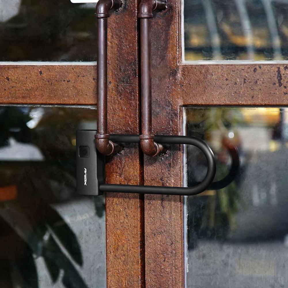 Black U-lock securing a wooden gate