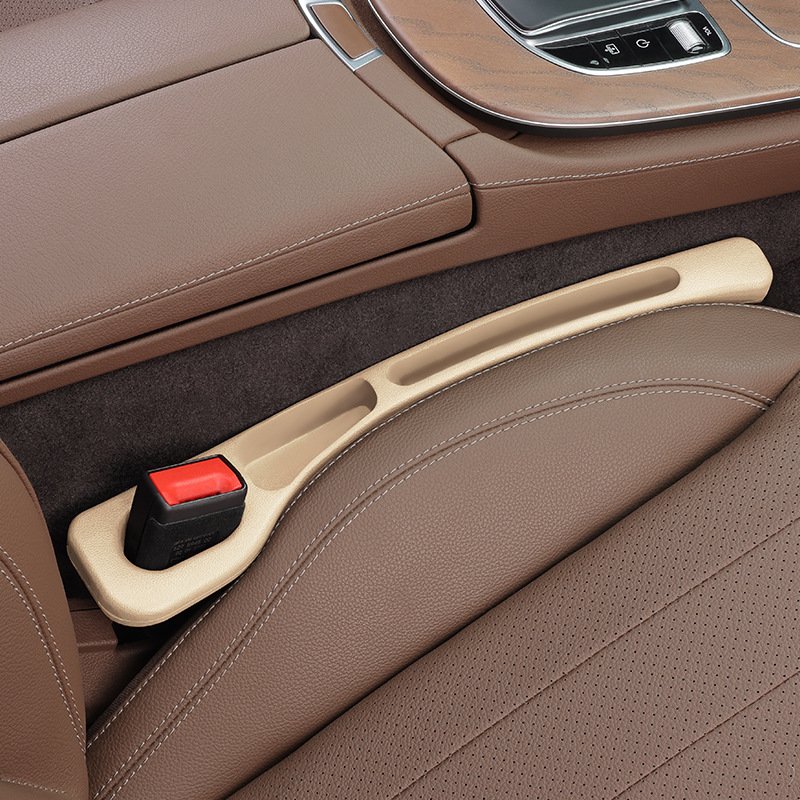 Beige CHICAMOR SeatSlot car seat gap filler installed between a brown leather car seat and the centre console