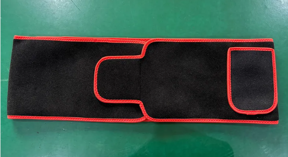ReviveFlex red light therapy belt in black with red edging, laid flat, outer side with a pocket flap