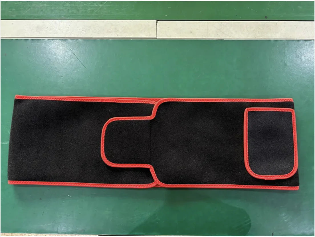 ReviveFlex red light therapy belt in black with red edging, laid flat on a green mat