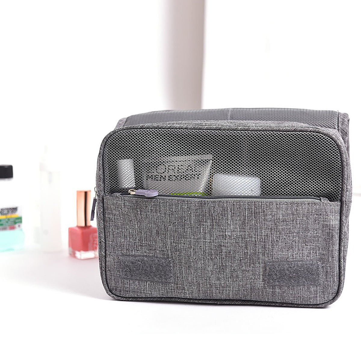 Front of the gray toiletry bag with a mesh pocket holding toiletries