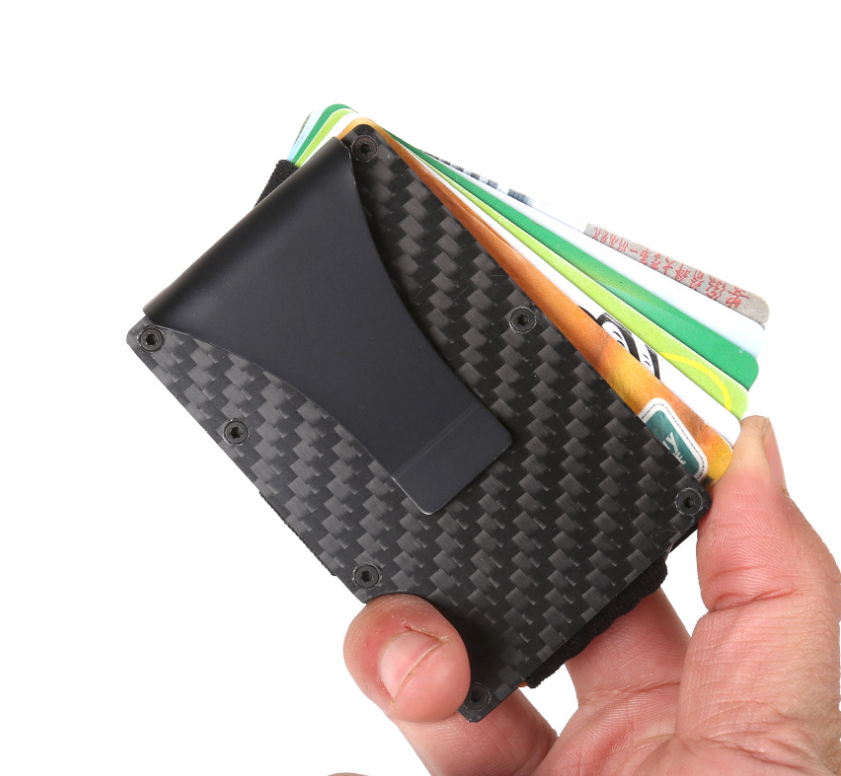 Hand holding the black carbon-fiber MagShield card holder with several cards fanned out of the top