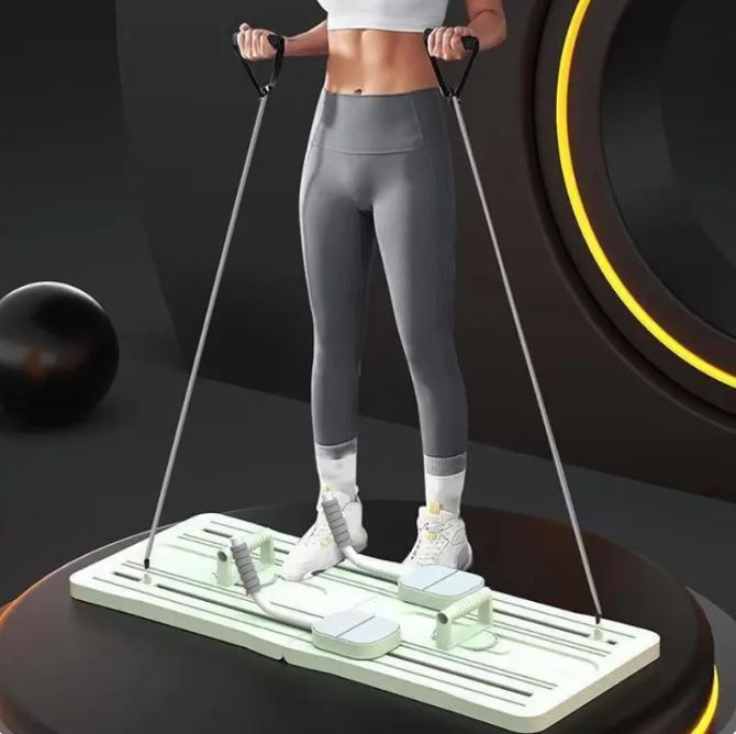 Woman standing on a pale green pilates board with resistance cords attached