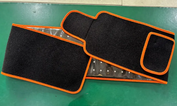 ReviveFlex red light therapy belt in black with orange edging, laid open to show rows of LED lights