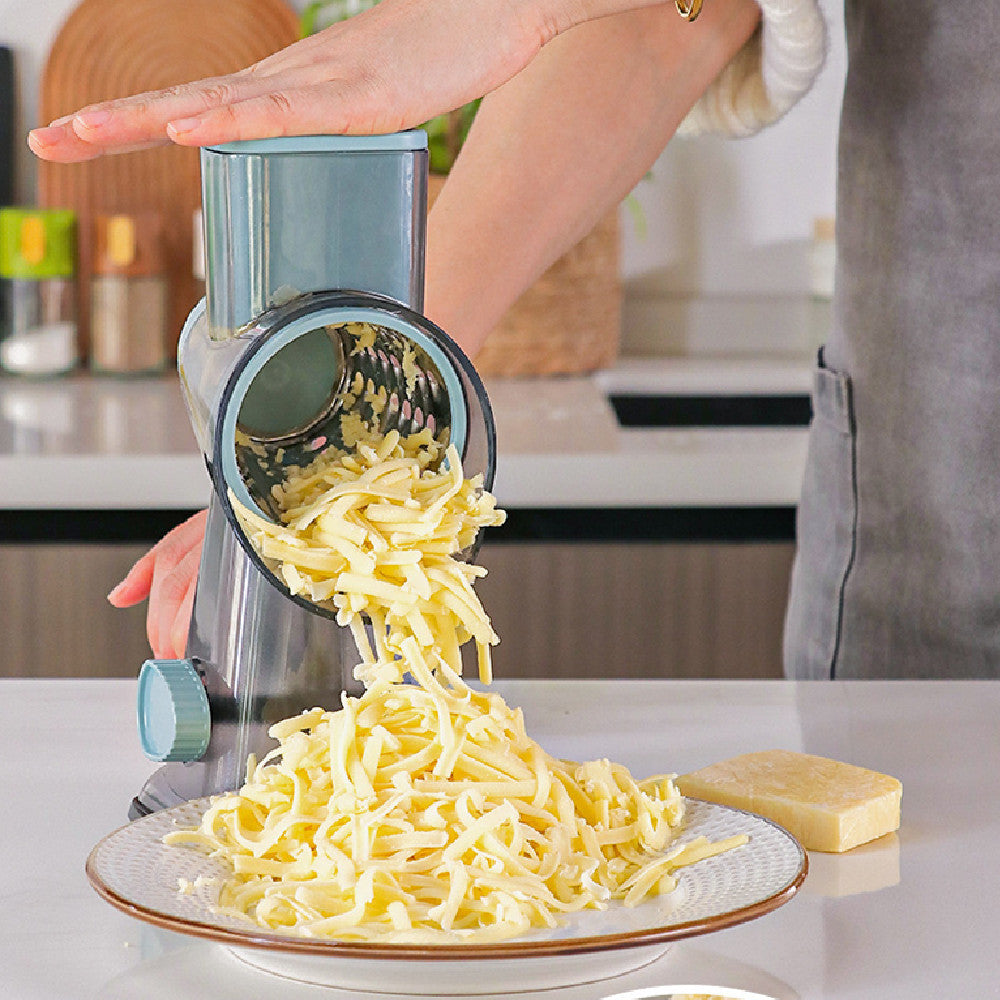 Hand grating cheese with a rotary drum grater onto a plate