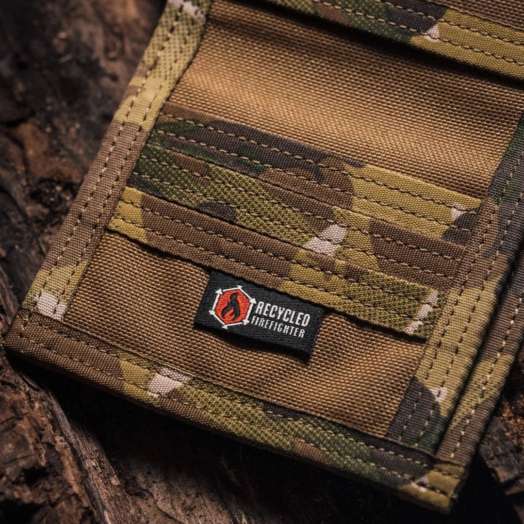 Close-up of a camouflage wallet interior with a small logo tag on a wooden surface