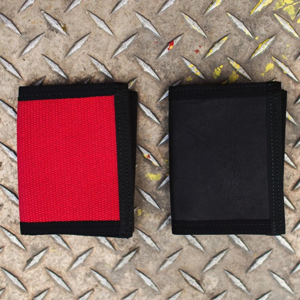 Red and black Captain Wallets side by side on a metal diamond-plate surface