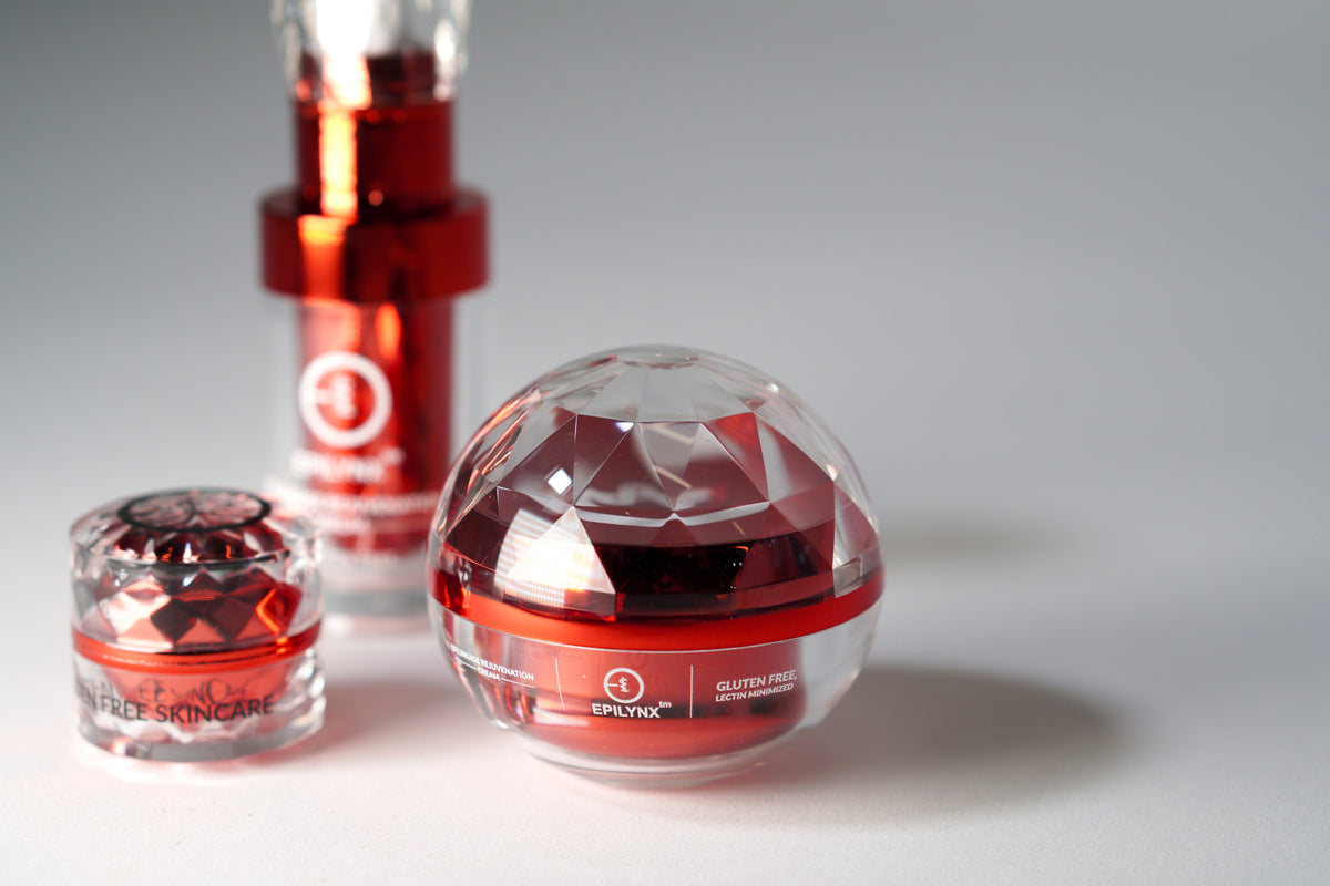 Red cream jar and serum bottle on a gray background