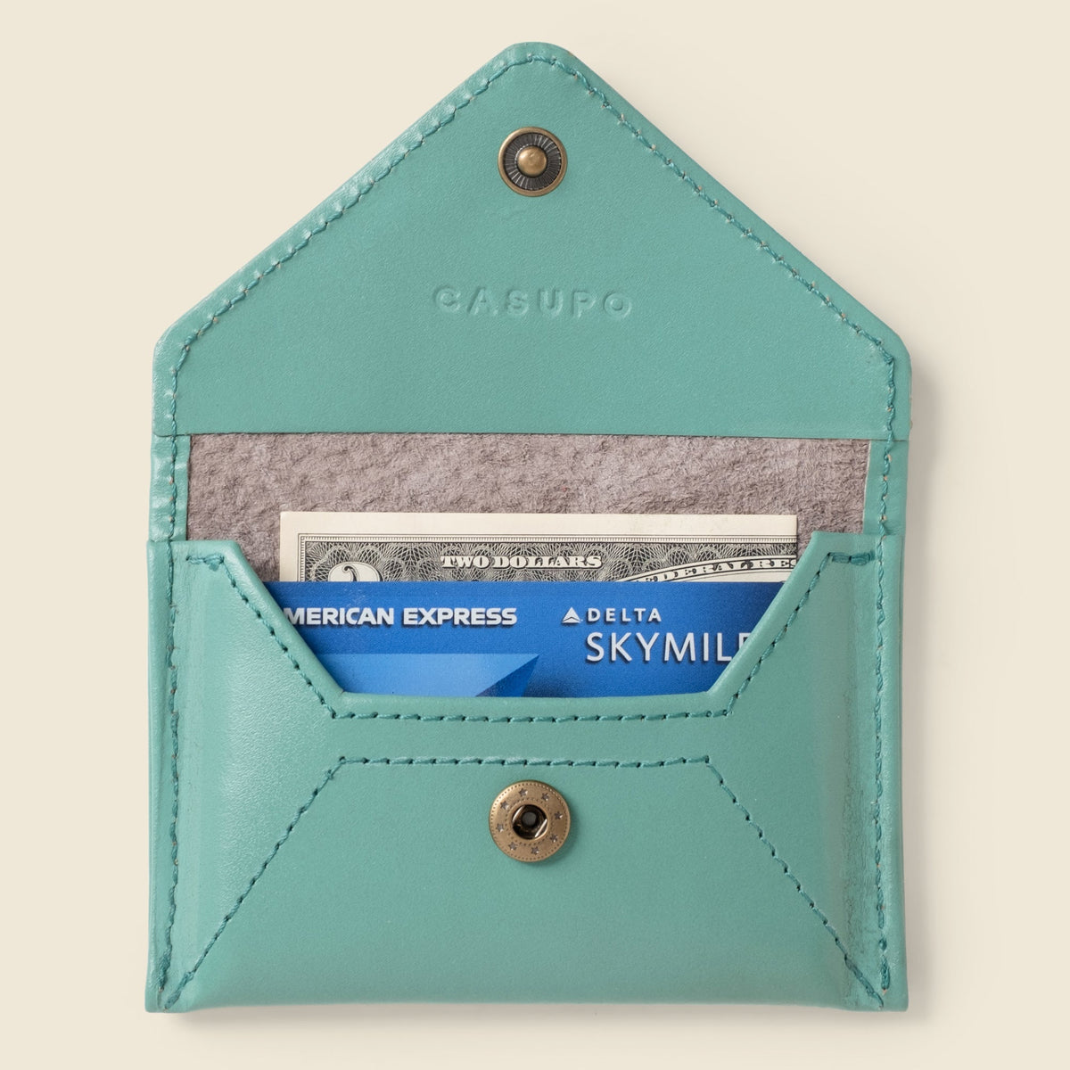Open CASUPO teal mini envelope wallet holding cards and cash in the front pocket