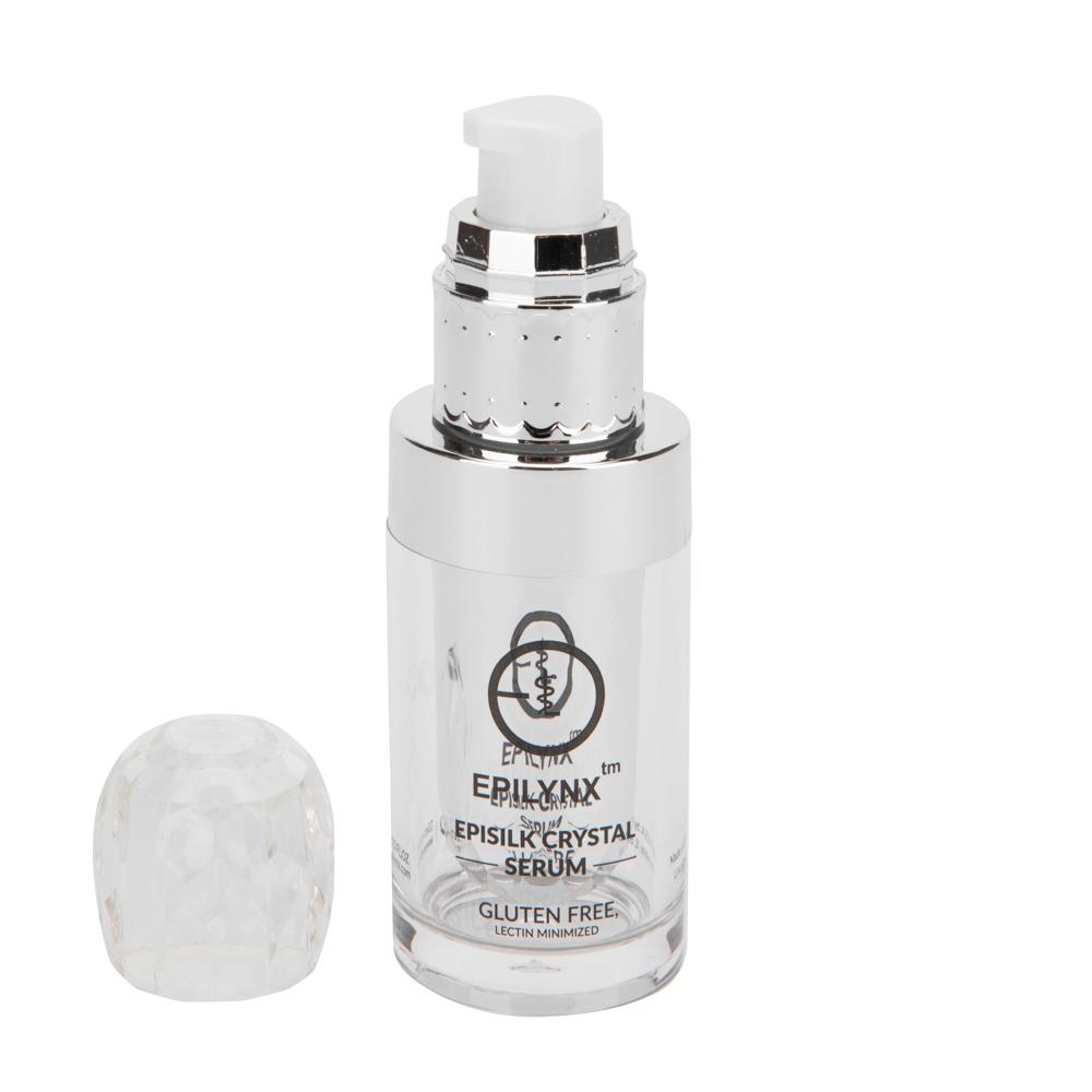 Silver serum bottle with its clear crystal-style cap set beside it