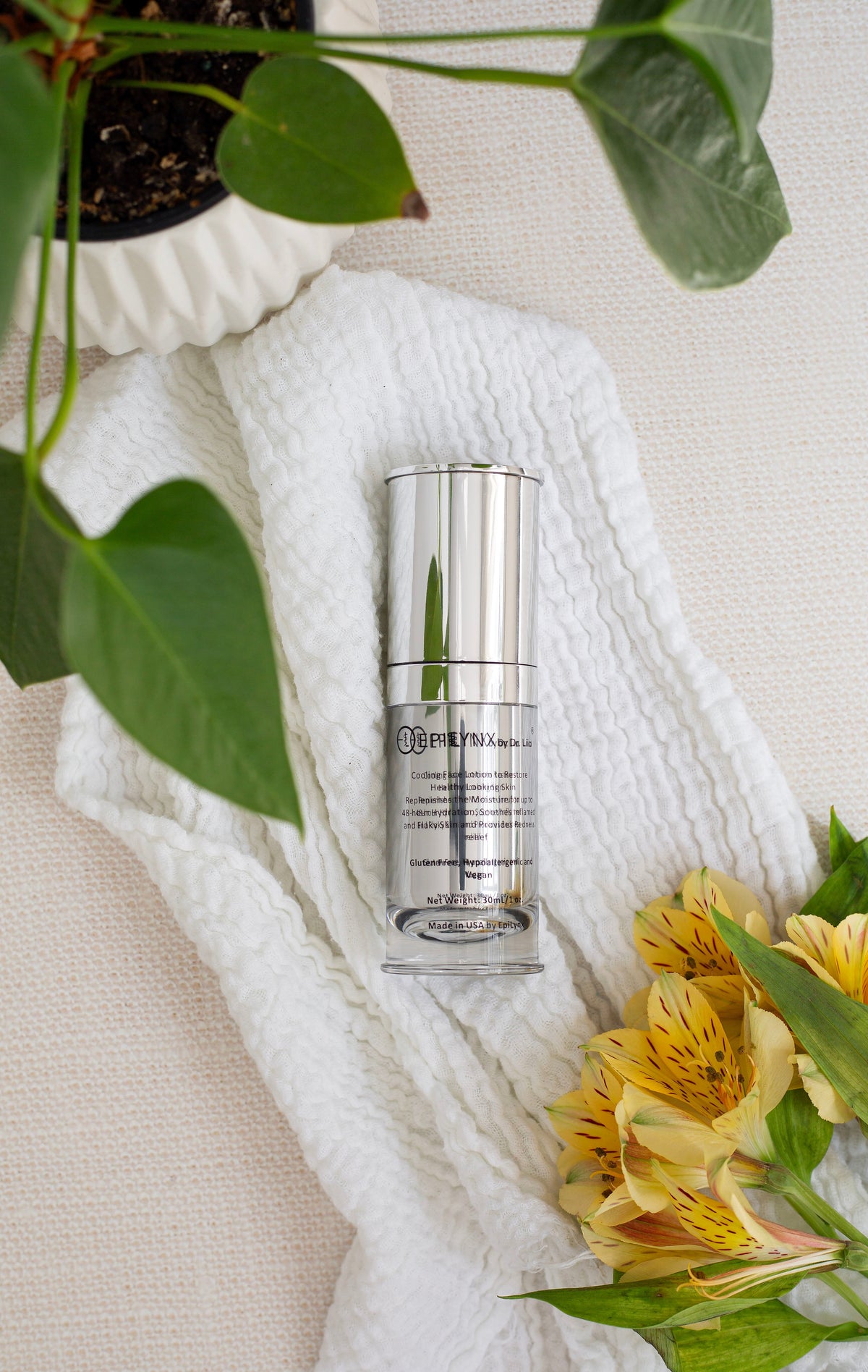 EpiLynx moisturizer bottle on white fabric beside a plant and yellow flowers