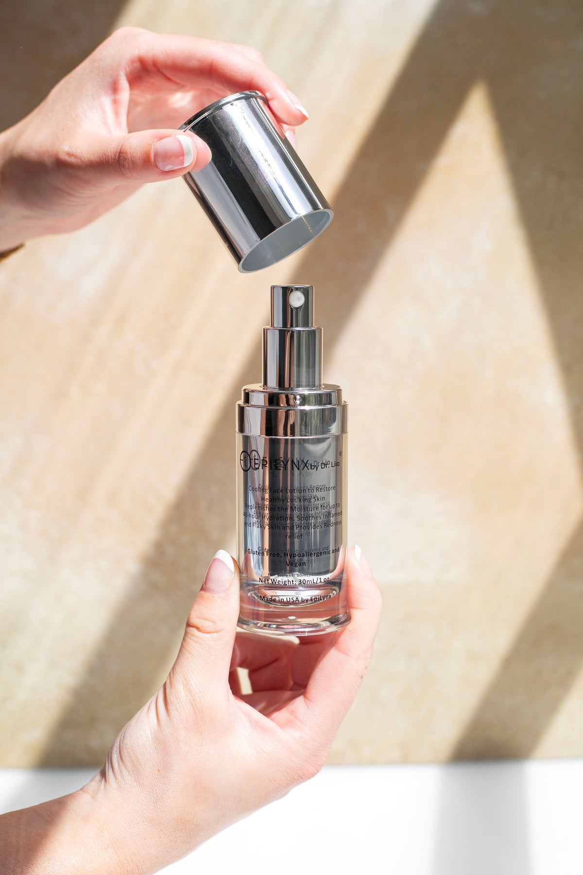 Hands holding the EpiLynx moisturizer bottle in sunlight