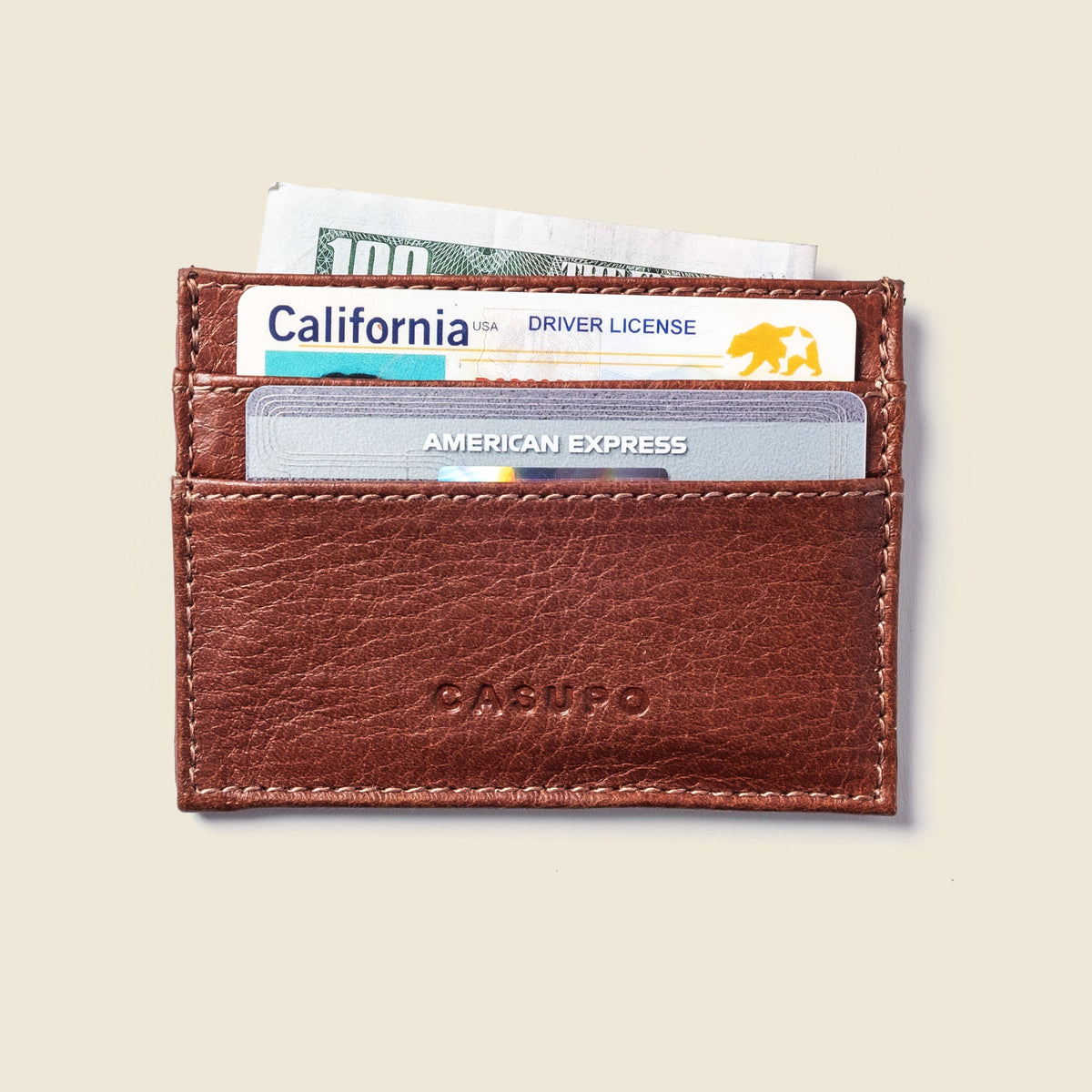 CASUPO slim card holder in chocolate brown leather holding cards and banknotes in its slots