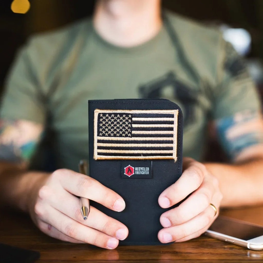 Man in a green T-shirt holding the black Field Notes Wallet with a US flag patch