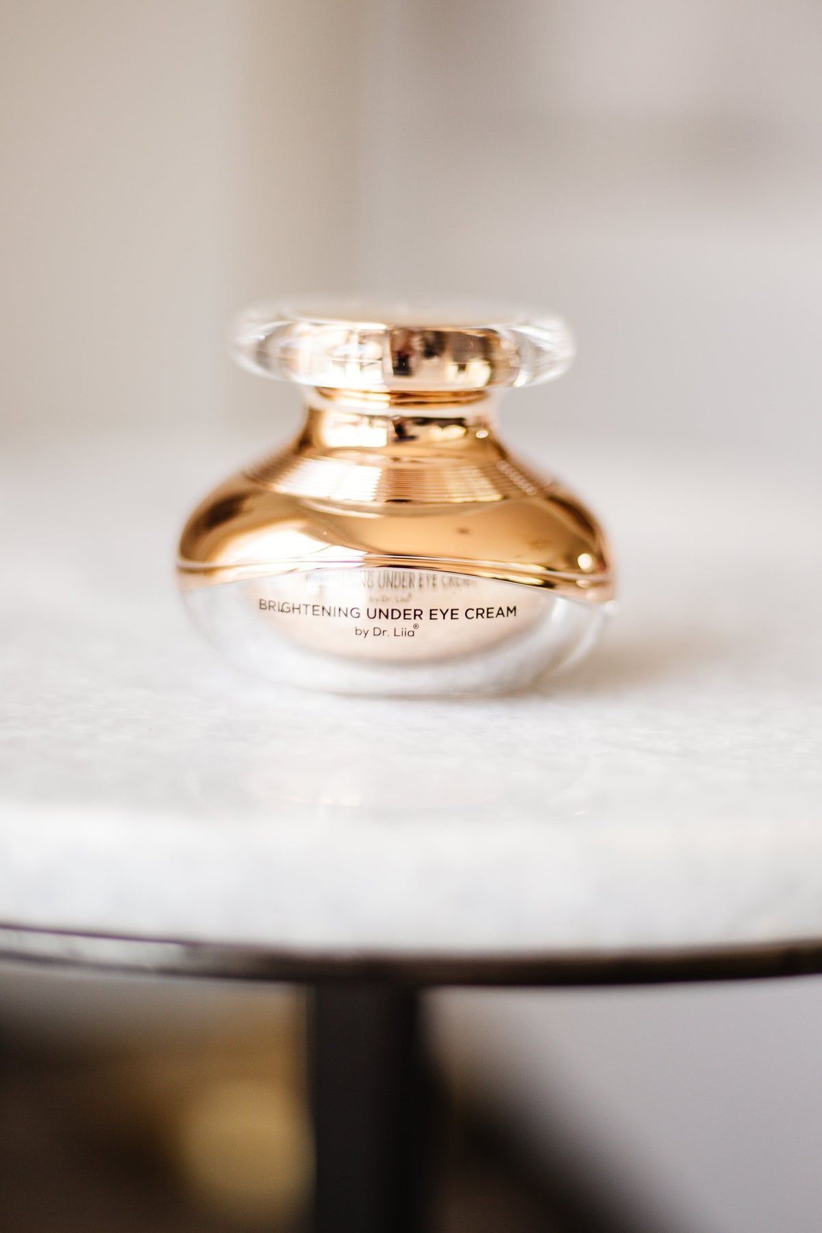 Closed gold EpiLynx eye cream jar on a marble table