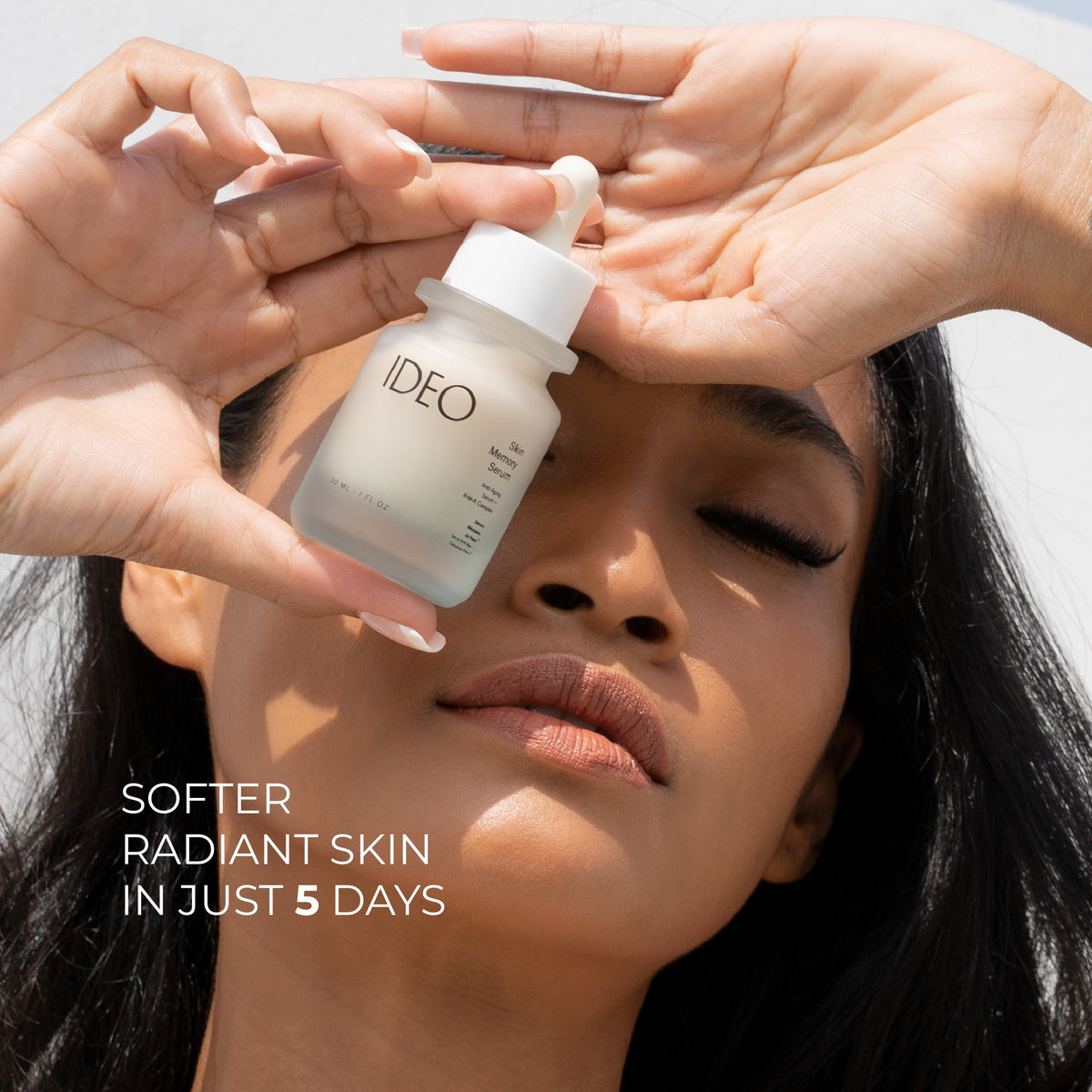 Woman holding the IDEO serum bottle against her forehead, with the text Softer radiant skin in just 5 days