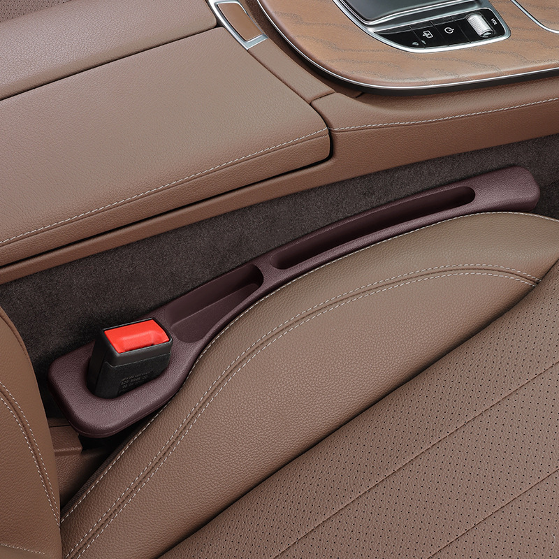 Brown CHICAMOR SeatSlot car seat gap filler installed between a brown leather car seat and the centre console