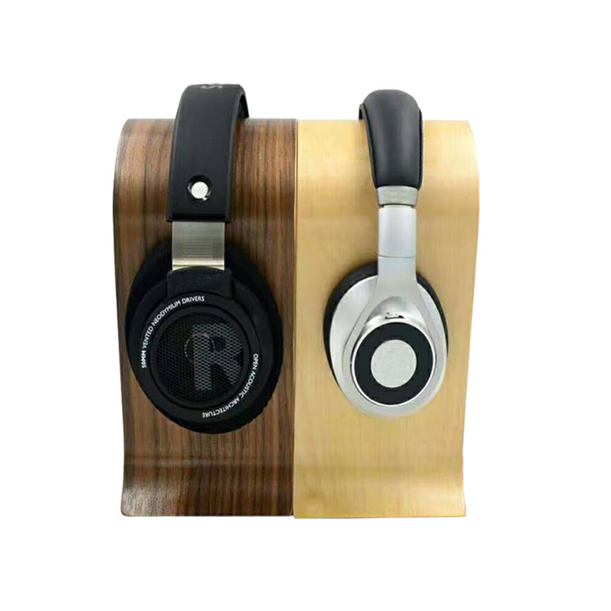 Two pairs of headphones, one black and one silver, on a double-sided wooden stand
