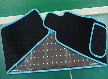 ReviveFlex red light therapy belt in black with blue edging, laid open to show rows of LED lights on the inner side
