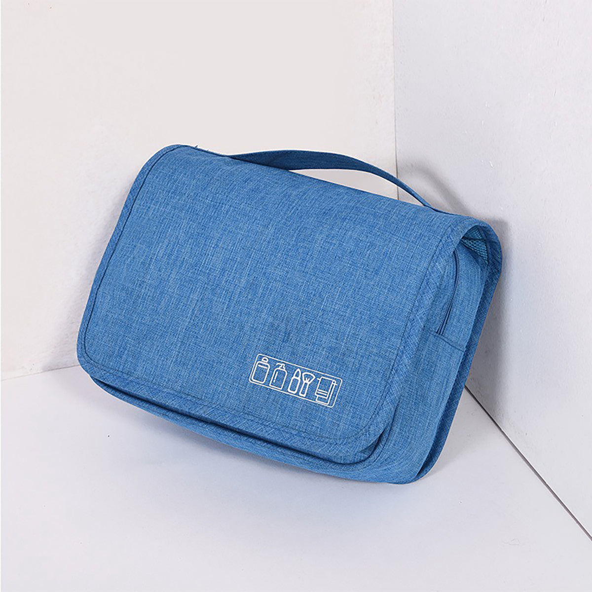 Blue hanging toiletry bag, folded, with a top carry handle