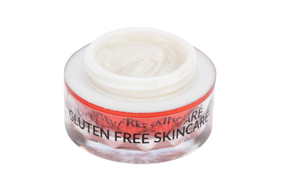 Close-up of a jar of white cream with a red base and gluten-free text on the glass